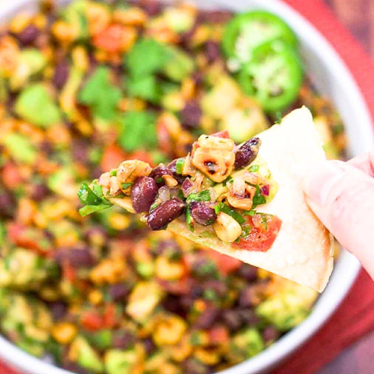 A tortilla chip filled with fresh avocado salsa as an appetizer. Hostess At Heart