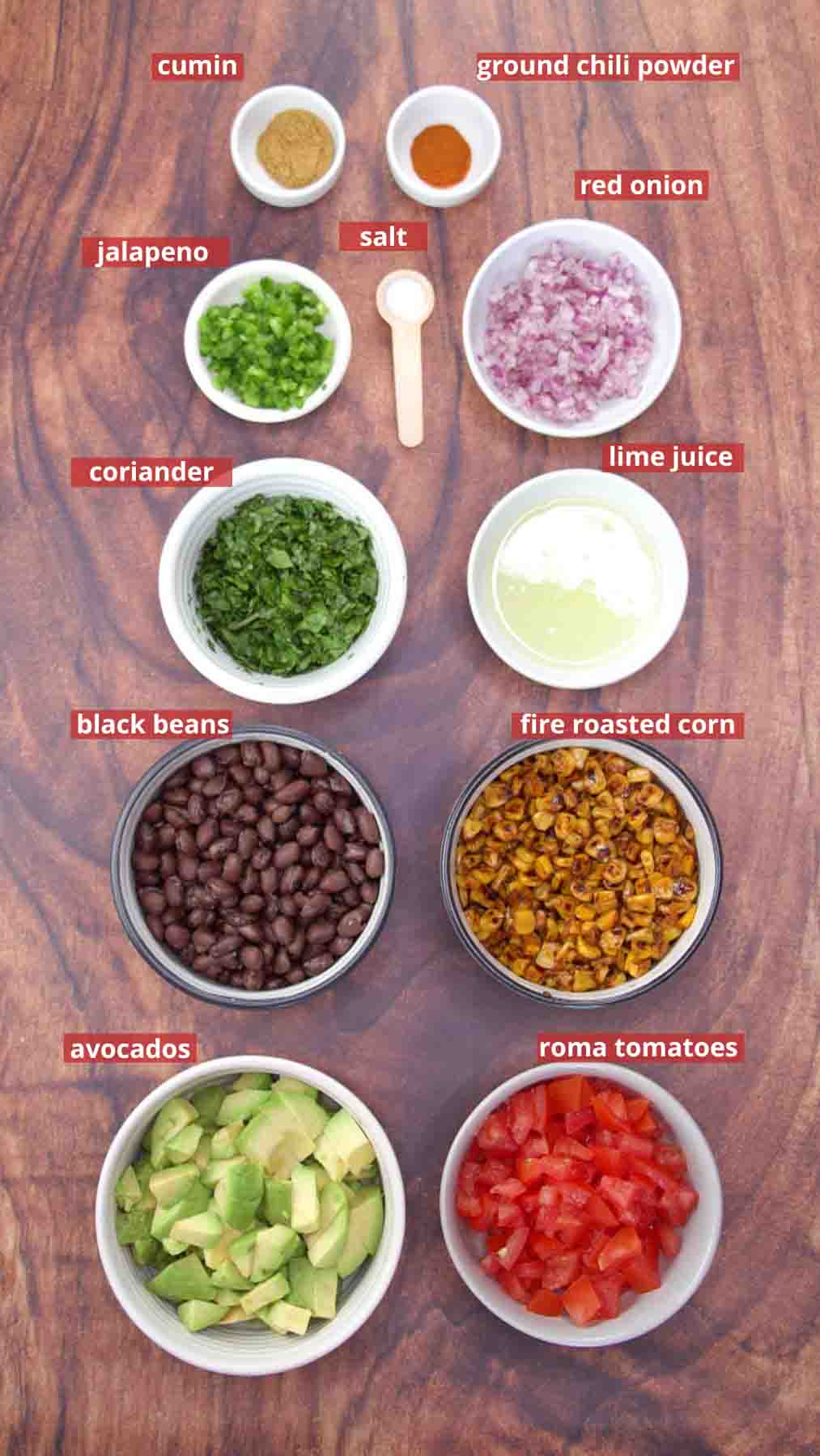 Ingredients for fresh avocado salsa including avocado, fire-roasted corn, black beans, tomatoes, jalapeรฑo, and lime. Hostess At Heart