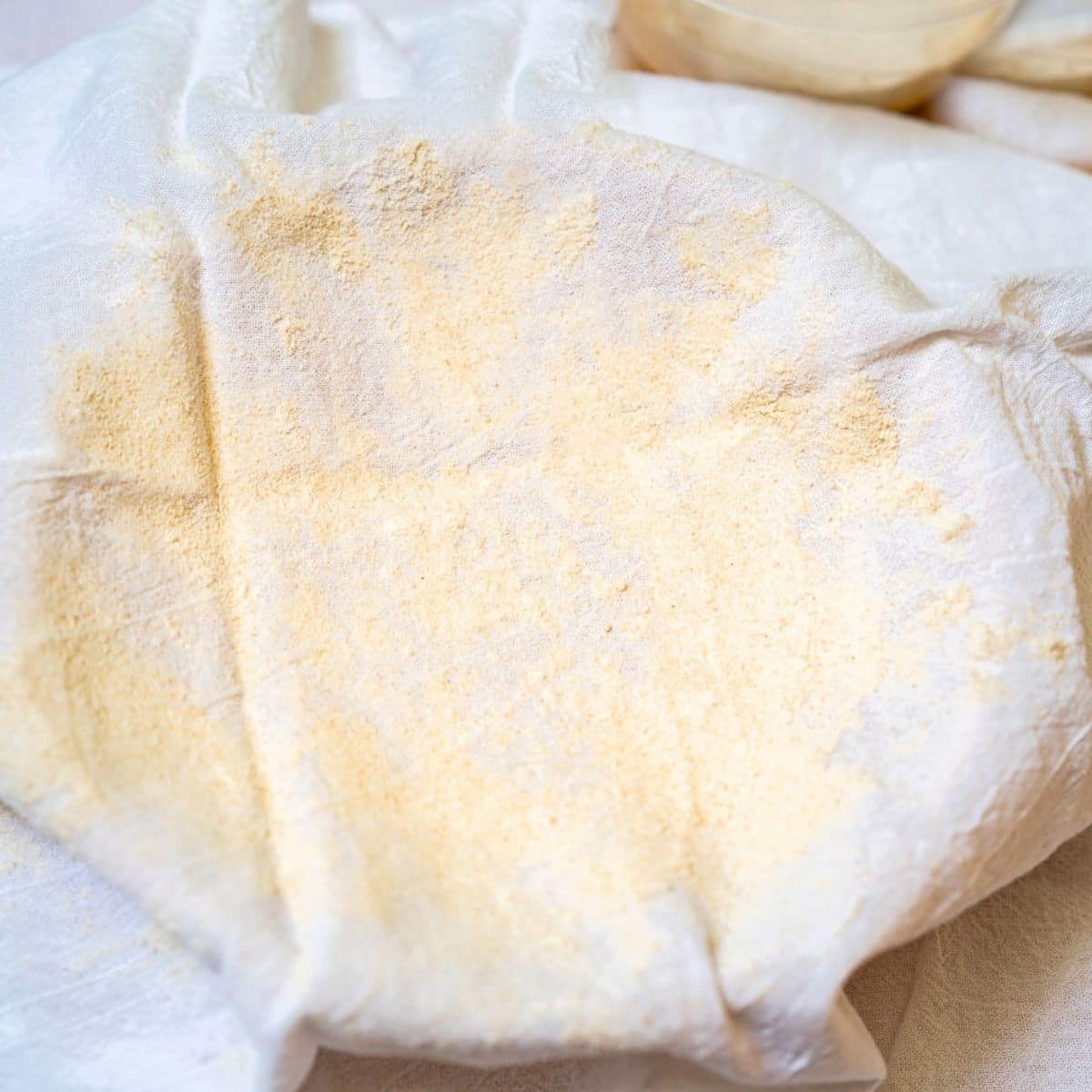 A flour sack that's been dusted with rice flour covering a basket to be used for rising a spelt sourdough bread recipe. Hostess At Heart