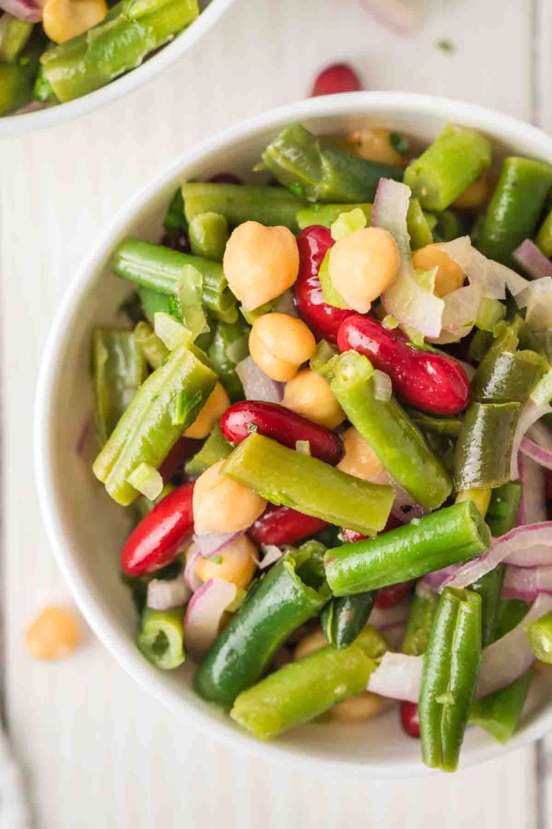 Top down view of a close-up of a quick three bean salad recipe with fresh parsley and colorful beans that will feed a crowd, perfect for cookouts. Hostess At Heart