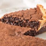 A slice of fudgy chocolate dessert showing a fudgy center and a flaky brownie top. Hostess At Heart