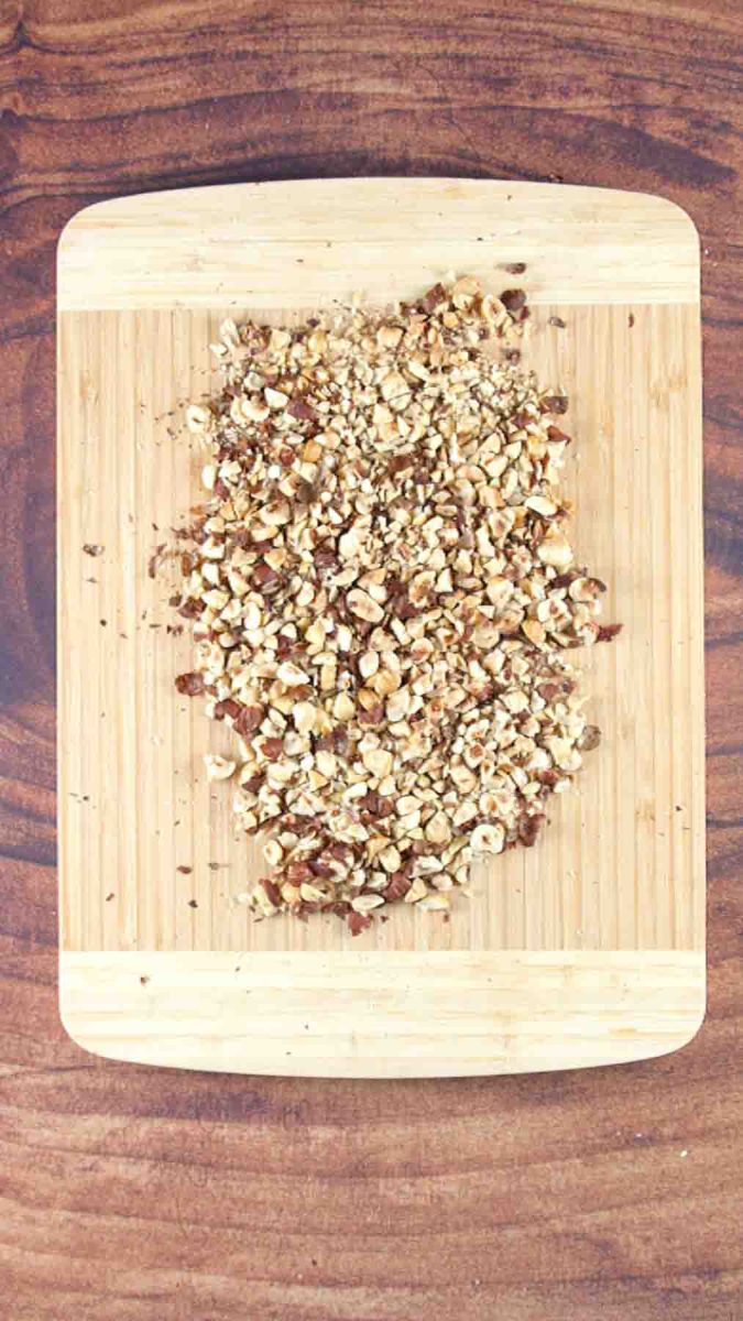 Chopped hazelnuts on a cutting board to make a Hungarian Hazelnut Layer Cake Recipe. Hostess At Heart
