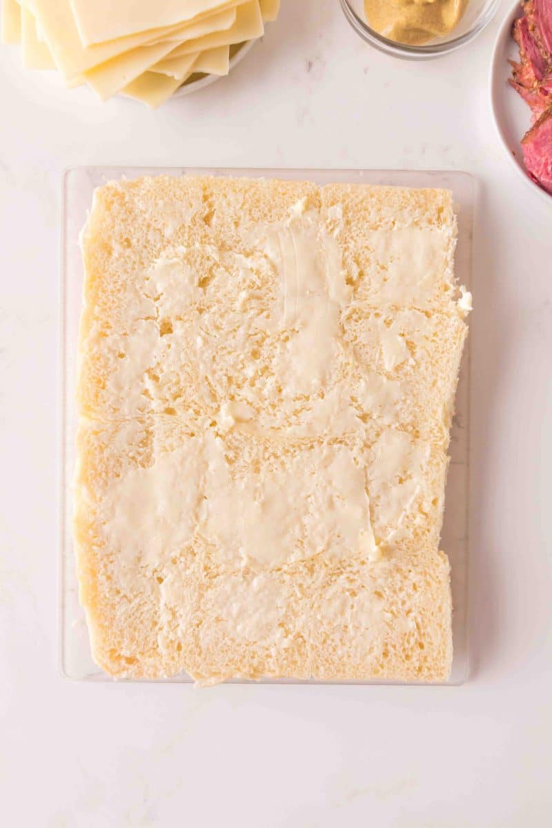Softened butter spread on the inside of Hawaiian rolls for corned beef sliders - Hostess At Heart
