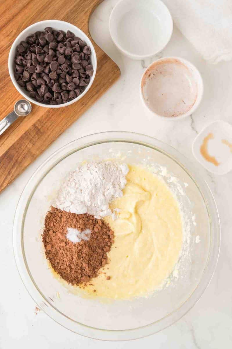 Dry fudgy pie recipe ingredients: flour, coco, and salt added to the wet creamy ingredients in a mixing bowl. Hostess At Heart