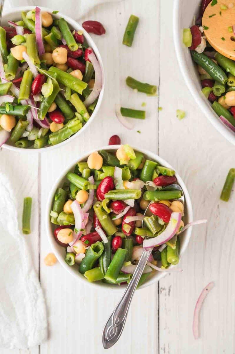 Top down view of individual white bowls filled with an easy 3 beans salad perfect for the Fourth of July and Memorial Day. Hostess At Heart