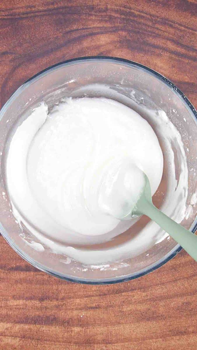 A mixing bowl filled with white icing to be spread over a Esterhasy Layer Cake. Hostess At Heart