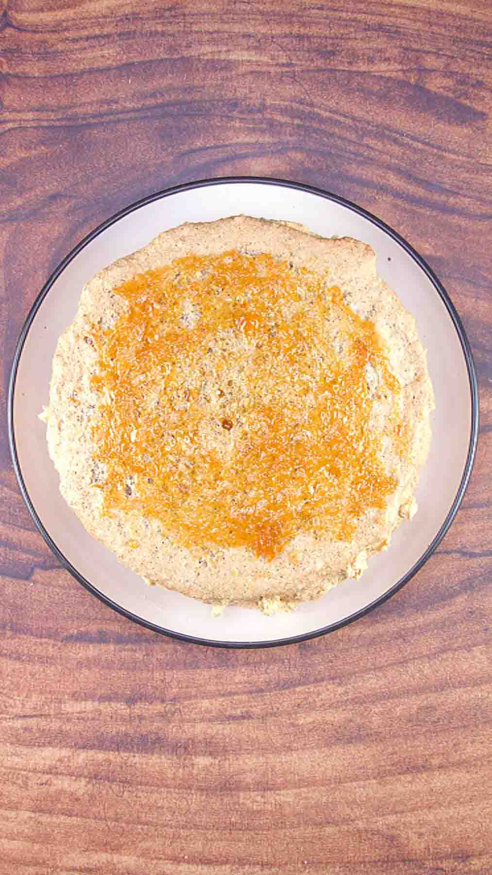 Applying apricot jam glaze to the top of the assembled Esterhazy Torte. Hostess At Heart
