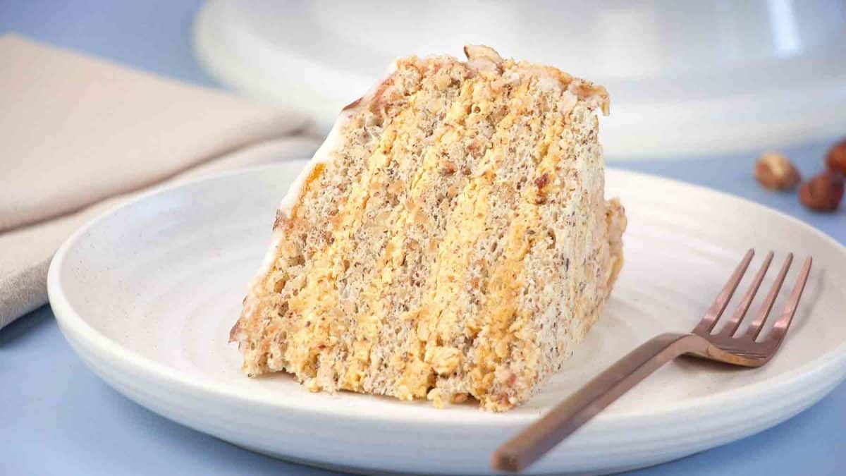 Side view of a slice of Esterhazy Torte cake showing layers of hazelnut meringue and buttercream. Hostess At Heart