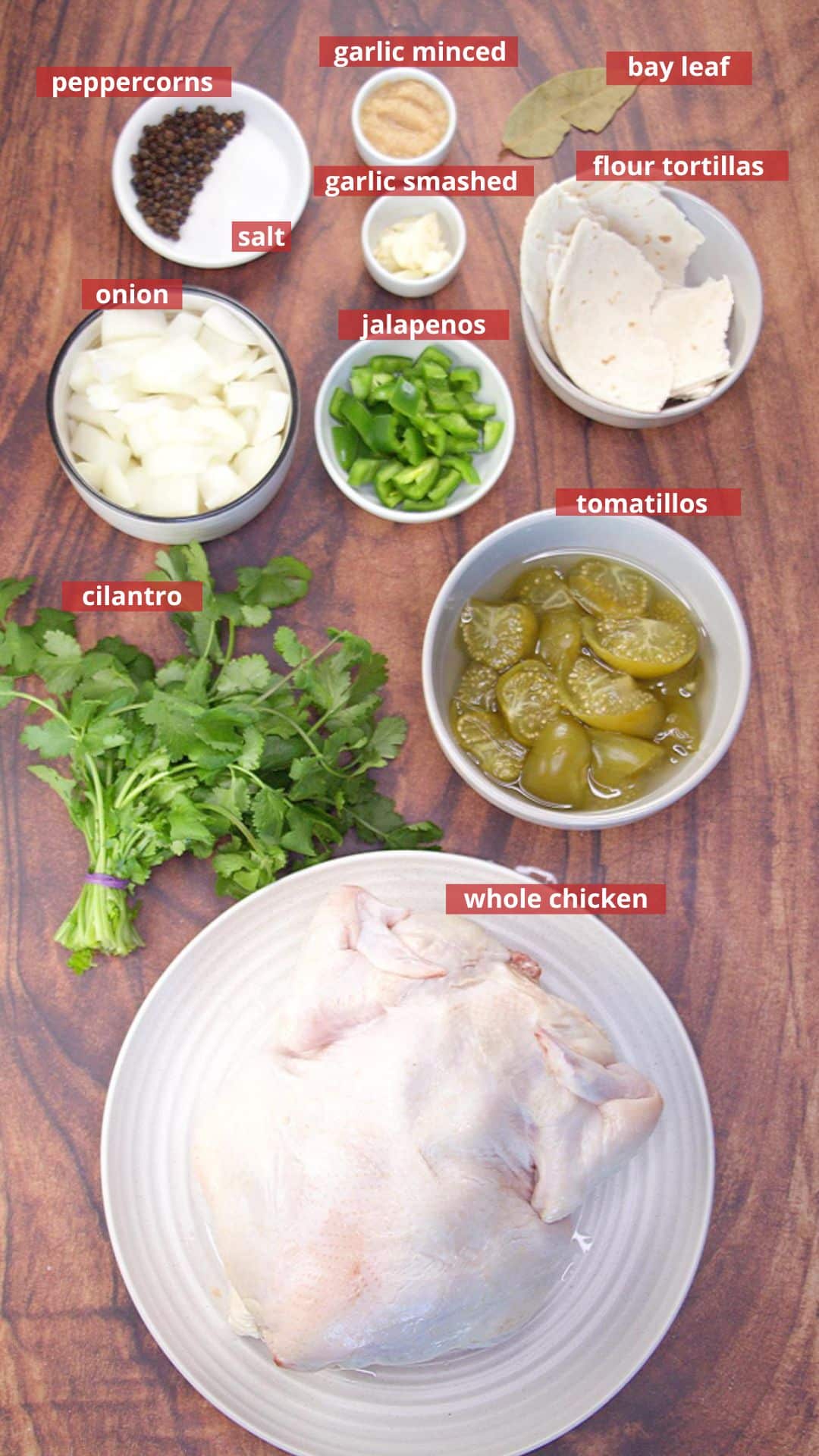 Ingredients to make a green chicken enchilada recipe including: tomatillos, jalapenos, while chicken, onion, garlic, peppercorns, cilantro, minced garlic, salt, and torn tortillas. Hostess At Heart