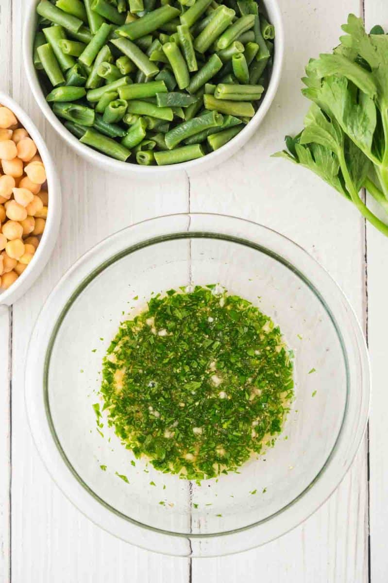 A mixing bowl containing three bean dressing ingredients apple cider vinegar and maple syrup dressing for 3 bean salad. Hostess At Heart