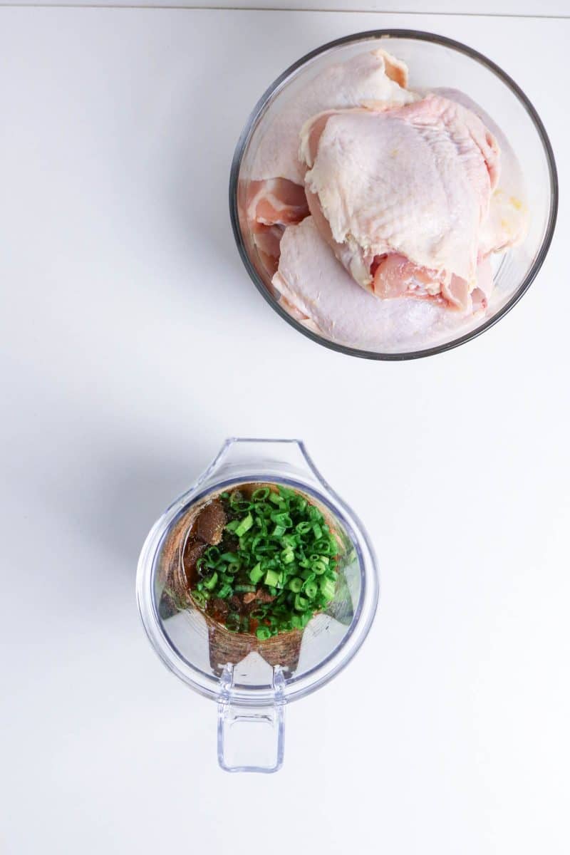 Jerk chicken marinade with green onions, garlic, and spices in a mixing bowl ready to be blended together. Hostess At Heart