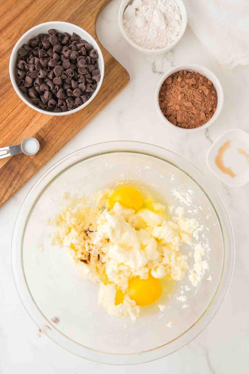 A mixing bowl filled with eggs added to a mix of whipped butter and sugar. Hostess At Heart
