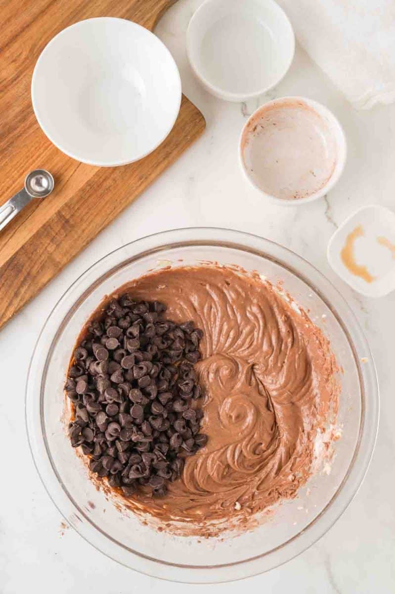 A mixing bowl filled with semi-sweet chocolate chips added to chocolate fudge pie batter. Hostess At Heart
