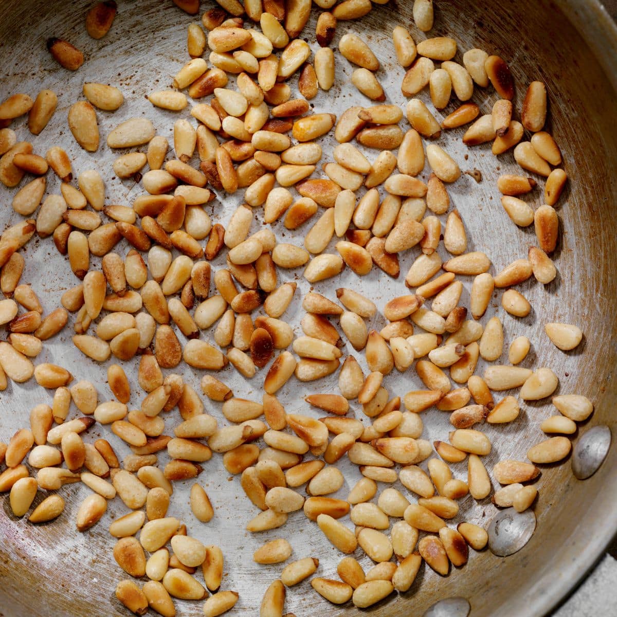 A skillet filled with roasted pine nuts. Hostess At Heart