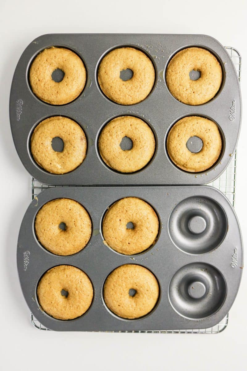 Baked dounuts in a donut pan cooling on a rack. Hostess At Heart