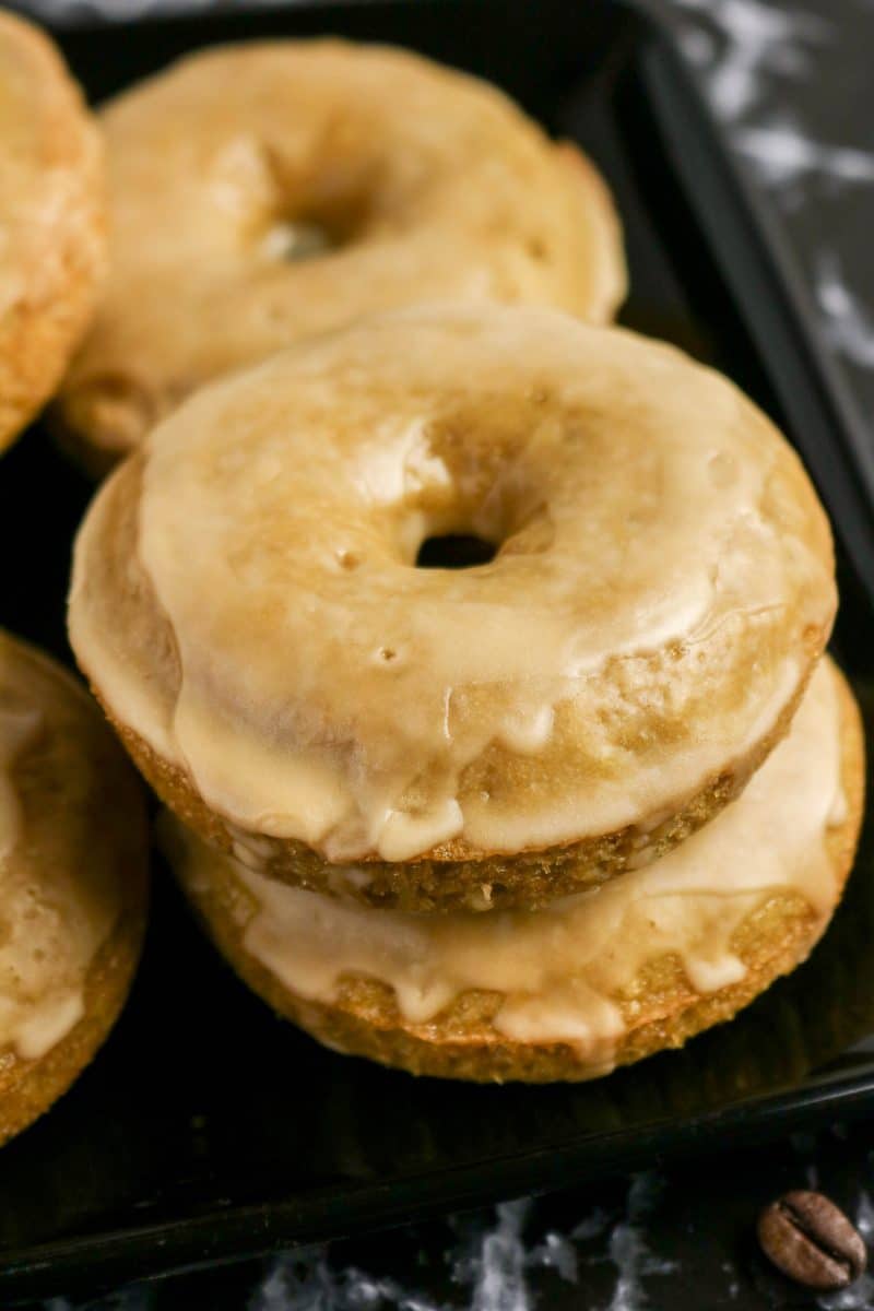 A stack of glazed coffee donuts on a serving tray. Hostess At Heart