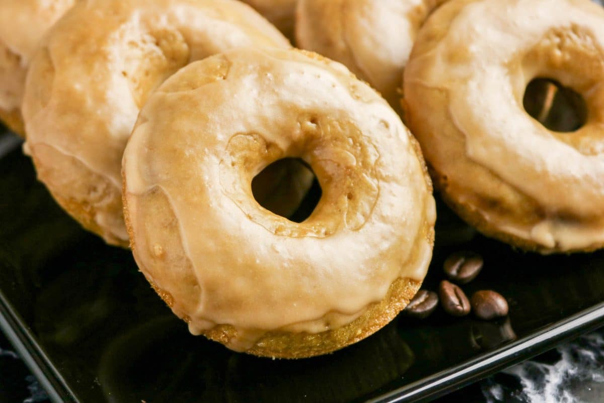 Stack of glazed coffee donuts on a black serving tray. Hostess At Heart