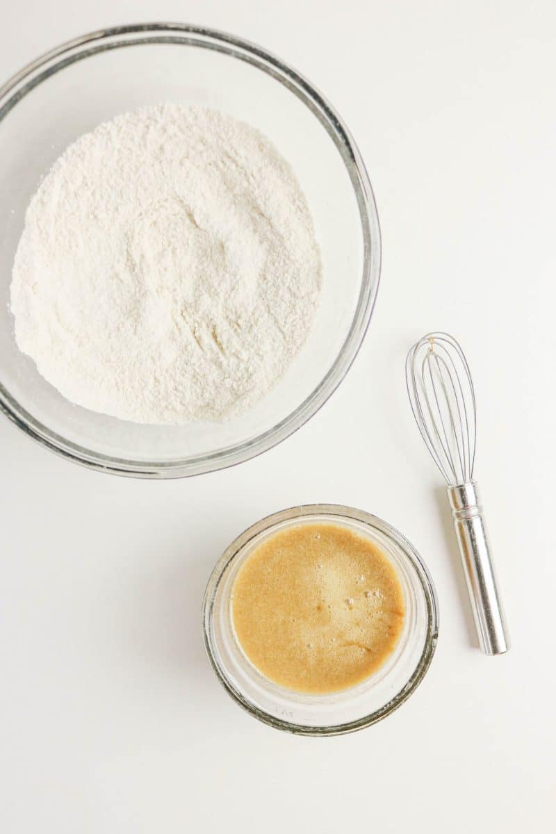 A mixing bowl filled with coffee donuts dry ingredients next to a bowl of wet ingredients including brewed coffee combined with egg, butter, and vanilla. Hostess At Heart