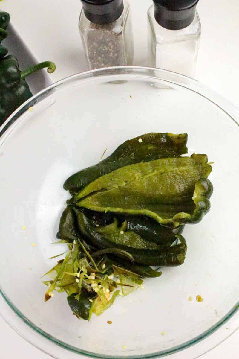 Roasted poblano peppers in a mixing bowl with the ribs and seeds removed to make green chili cheese dip. Hostess At Heart