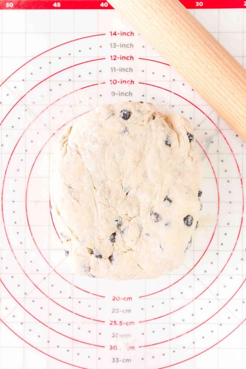 Blueberry biscuit dough on a rolling mat ready to be rolled into a rectangle. Hostess At Heart