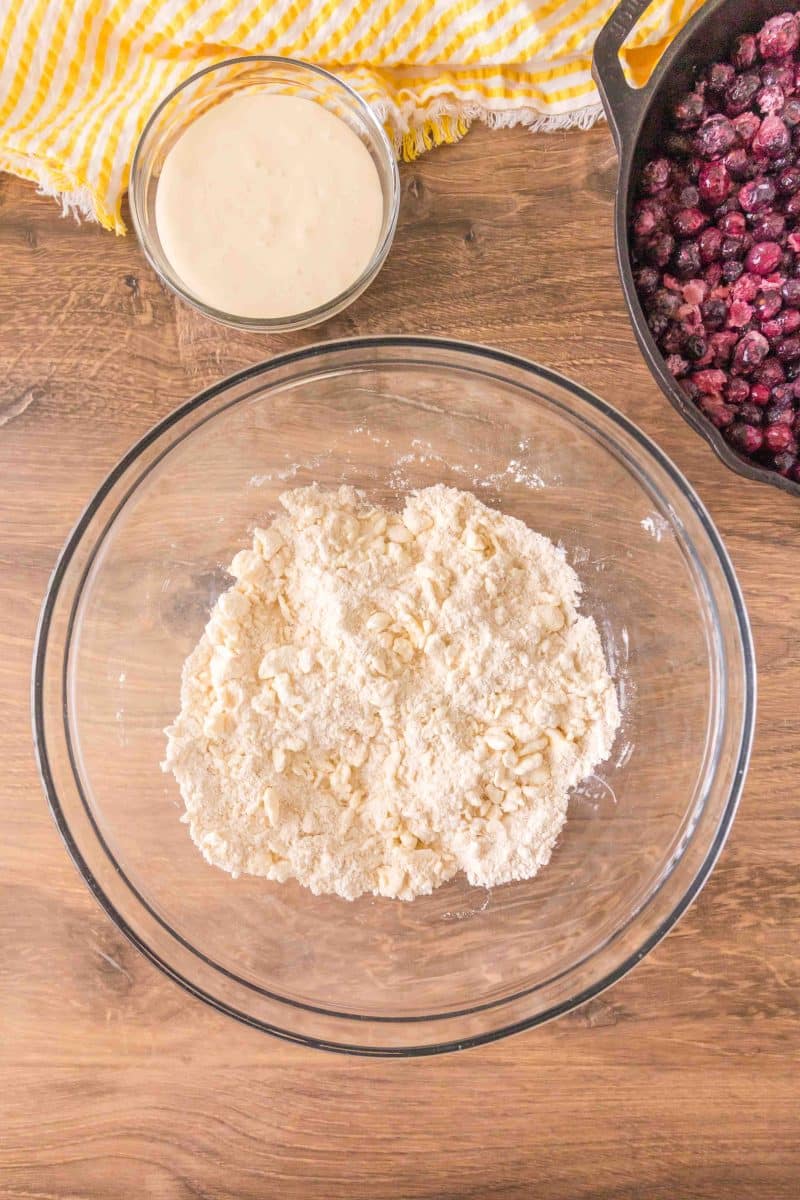 Butter cut into a mixing bowl containing a mixture of flour, baking soda, baking powder and salt to make sourdough discard blueberry cobbler crust. Hostess At Heart