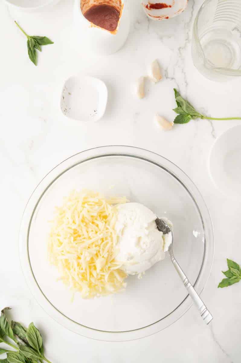 A mixing bowl containing freshly shredded mozzarella and ricotta cheese to make a cheese mix for 30 minute lasagna soup recipe. Hostess At Heart