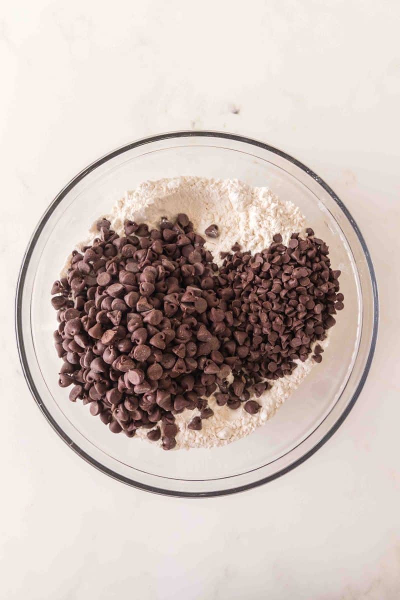 Coating chocolate chips in flour for crumble cookie recipe. Hostess At Heart