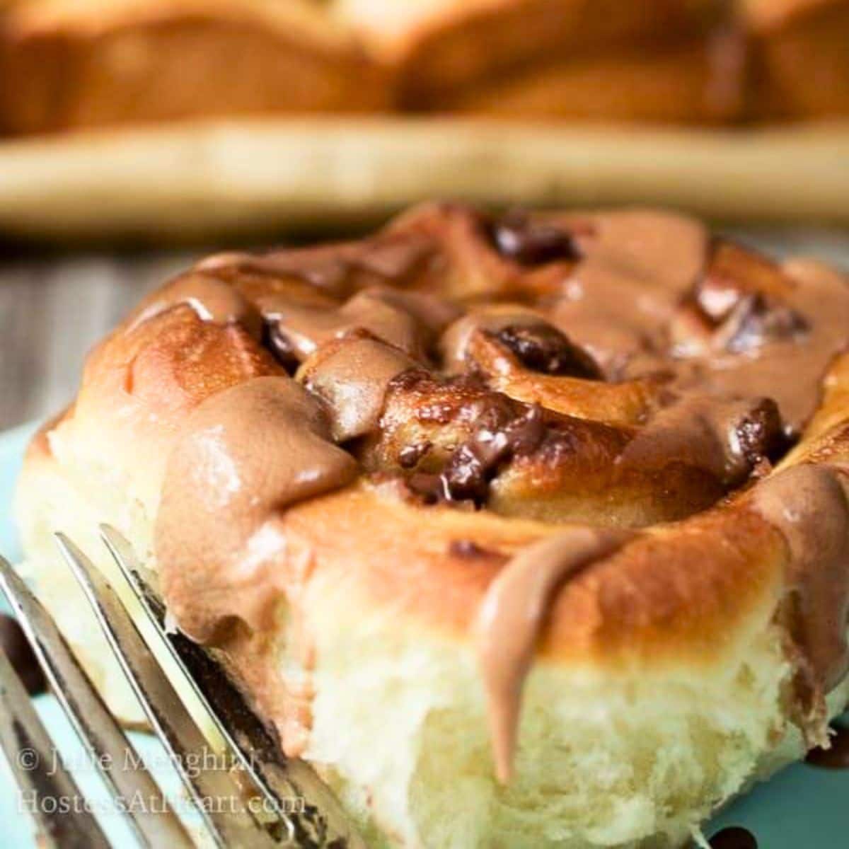 Close-up sideview of sweet rolls filled with chocolate chips and glazed with a malt flavored glaze to give it the taste of a chocolate malt. Hostess At Heart