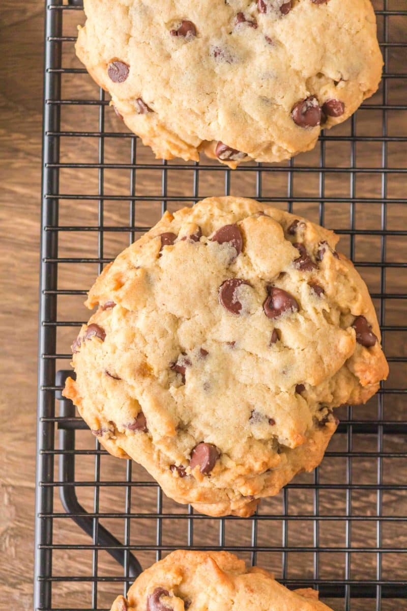 Top down view of a bakery style chocolate chip cookie on a wire rack. Hostess At Heart