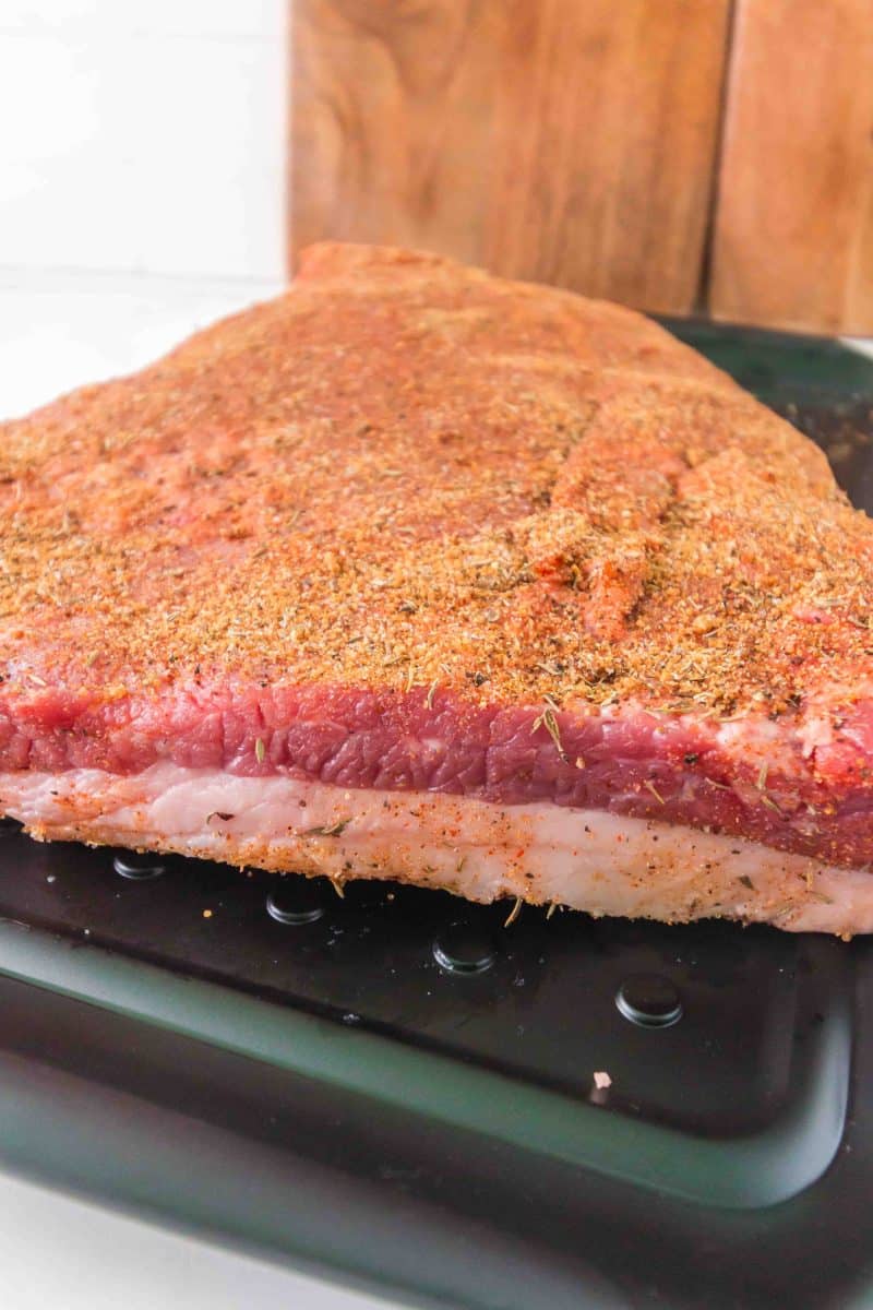 Sideview of a beef brisket that's been rubbed with dry spices. Hostess At Heart