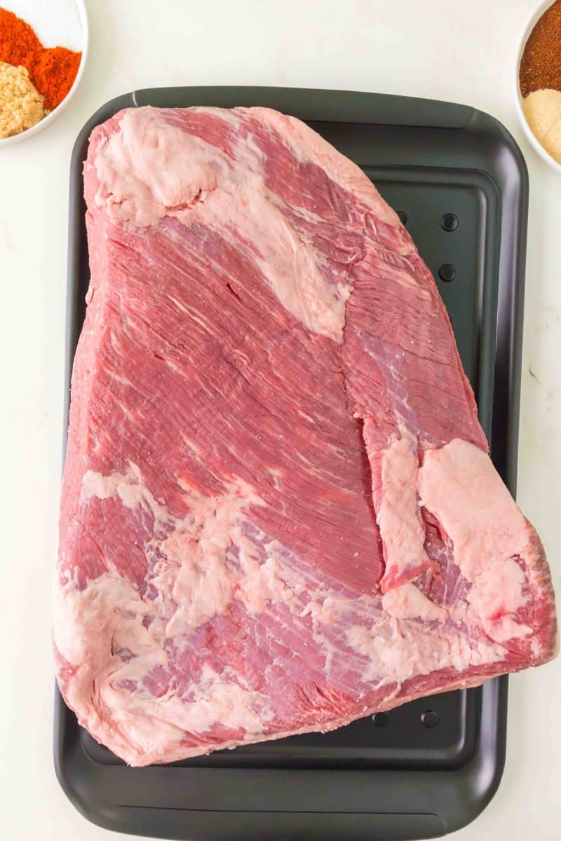 Top down view of a raw beef brisket that's had the fat cap trimmed to 1/4 inch before adding dry rub. Hostess At Heart