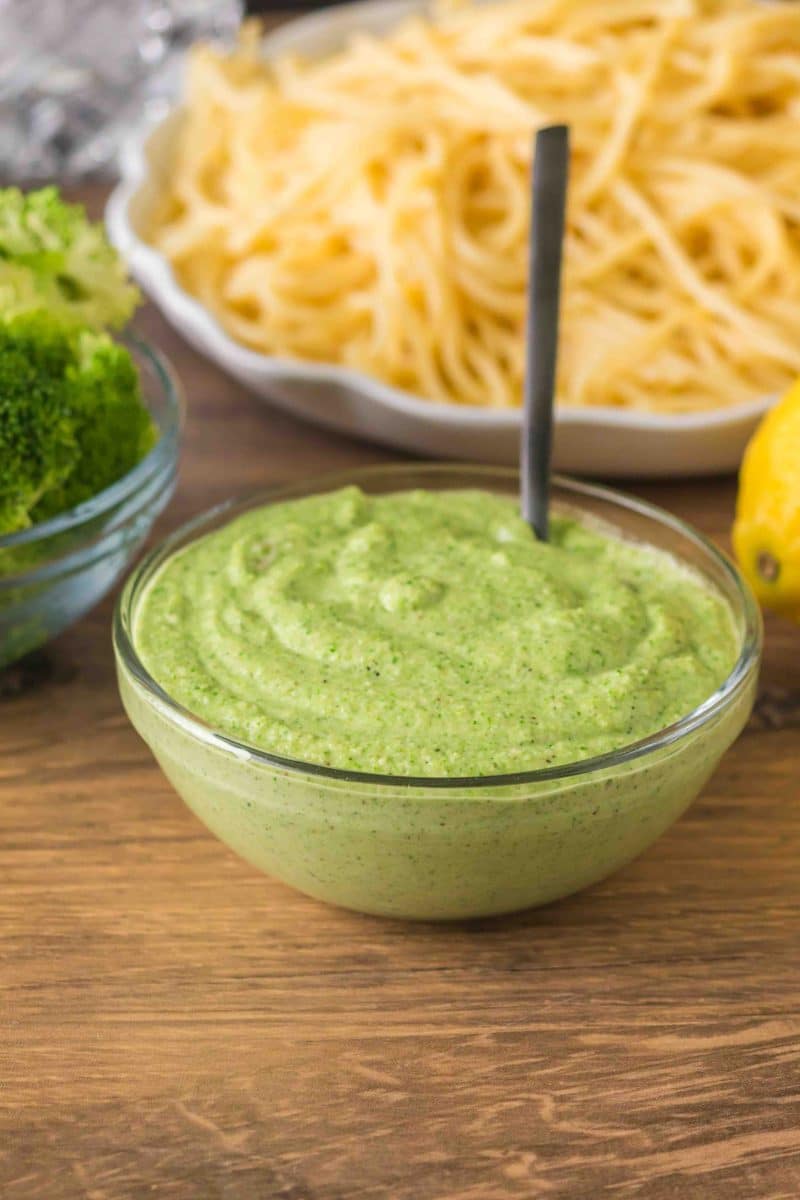 Sideview of a finished creamy broccoli pesto sauce in a glass bowl. Hostess At Heart