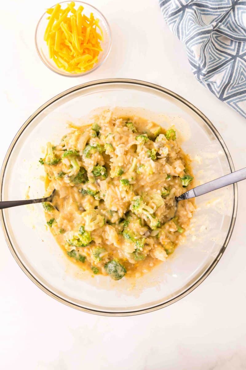 Cheese sauce being mixed in to a bowl of broccoli and rice. Hostess At Heart