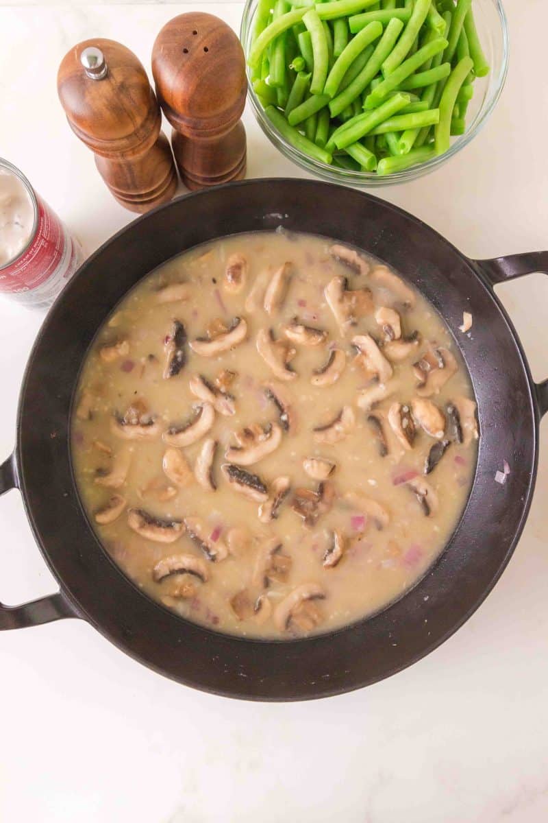 Broth added to a pan of sauteed sliced mushrooms and diced onion to make a fresh green bean casserole from scratch. Hostess At Heart