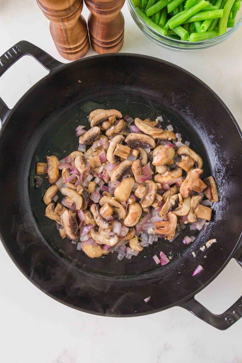 Sliced mushrooms and diced onion cooking in butter for creamy green bean casserole sauce. Hostess At Heart