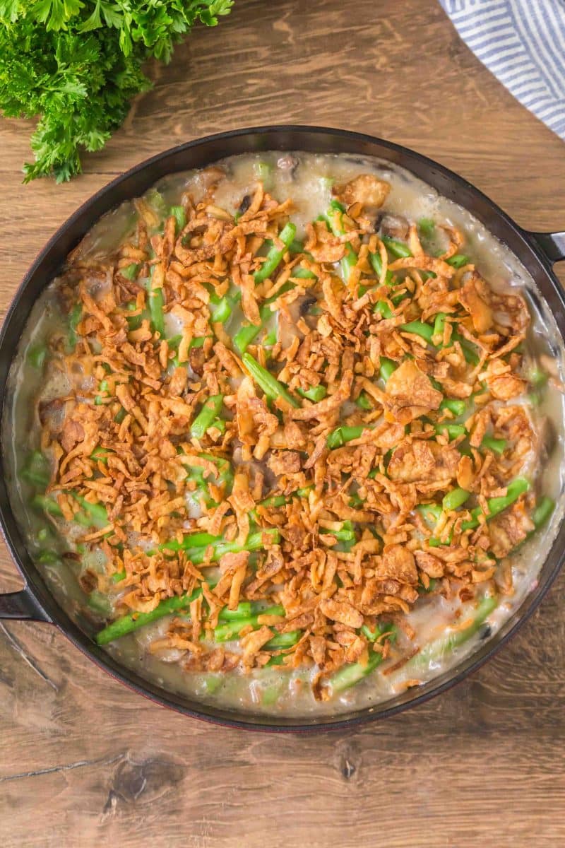 Top down view of Fresh Green beans casserole in a skillet topped with crispy fried onions. Hostess At Heart