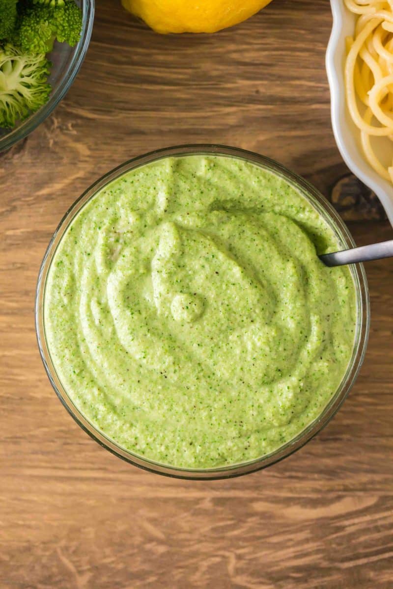 Overhead shot of finished broccoli pesto in a glass bowl. Hostess At Heart