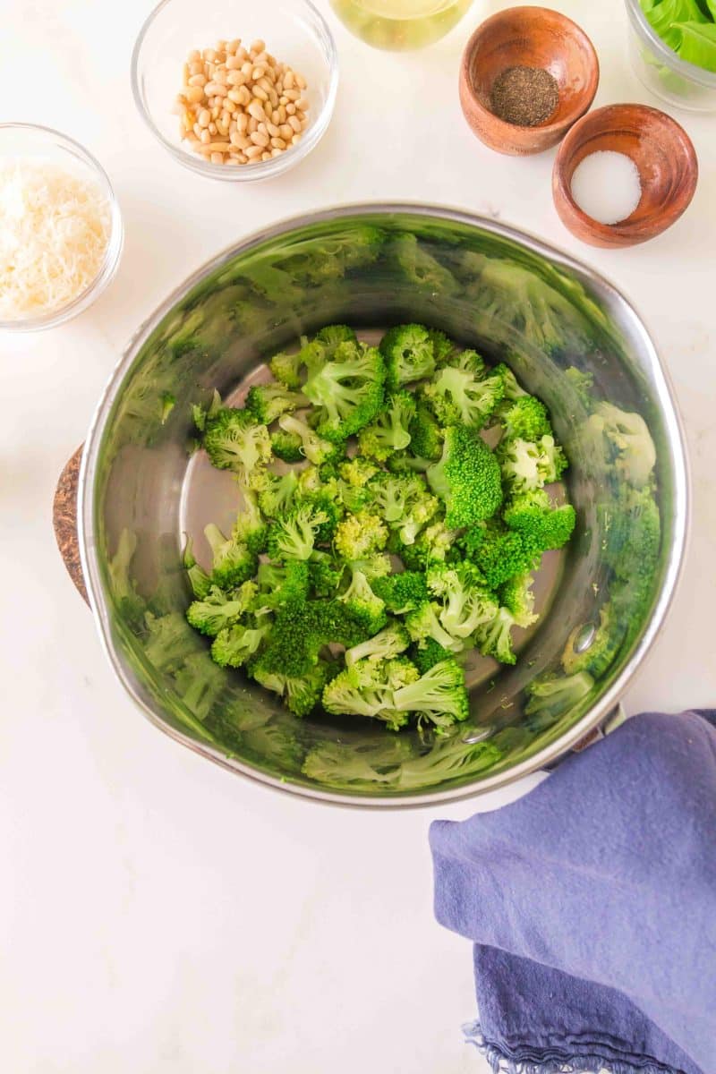 Top down view of broccoli in a saucepan that's been blanched and drained. Hostess At Heart