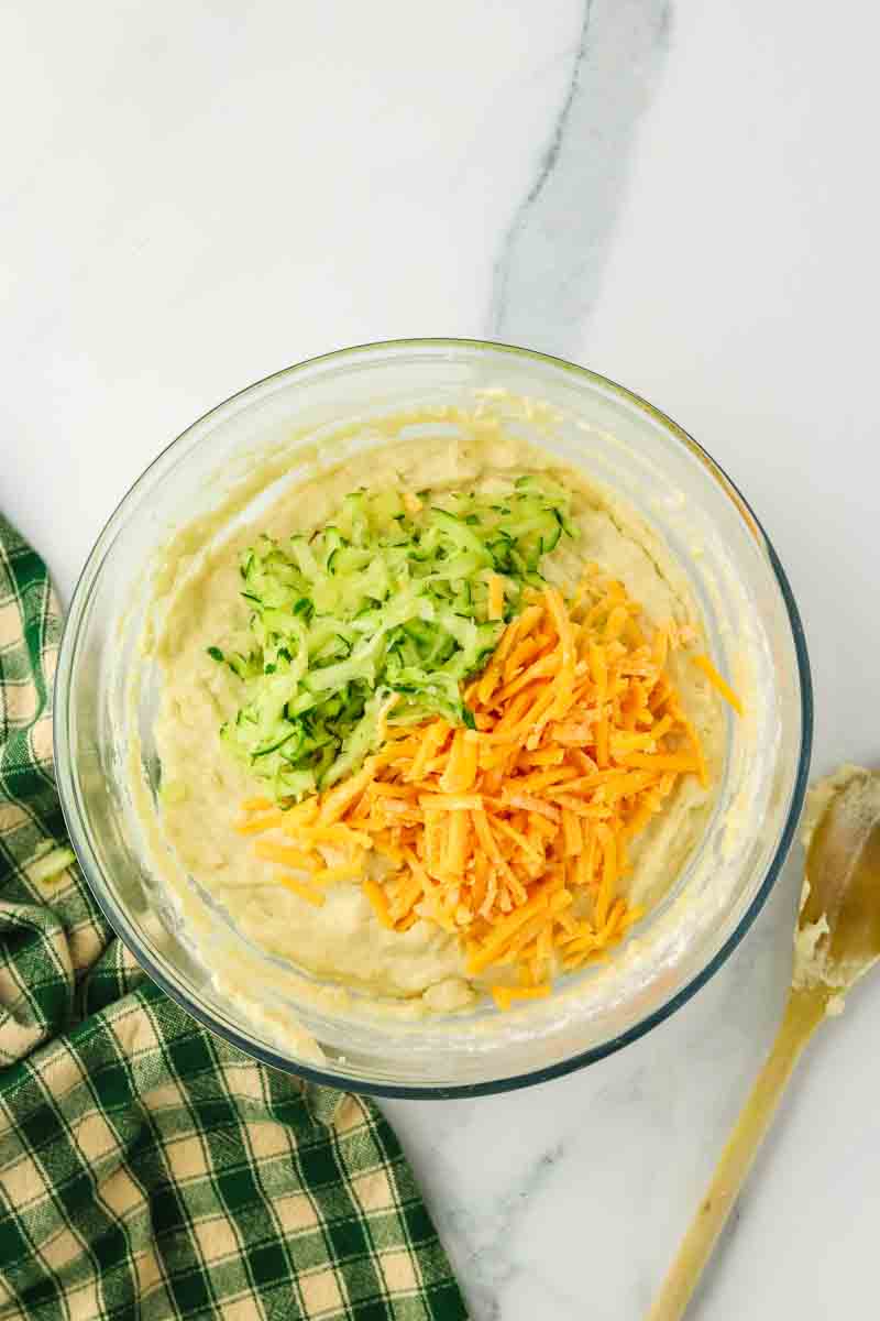 Cheddar cheese and zucchini being folded into bread batter. Hostess At Heart