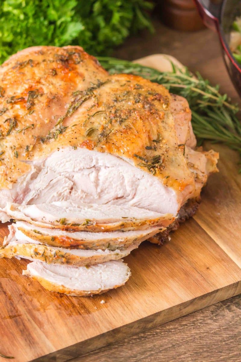 A golden brown baked turkey breast sliced showing juicy tender meat. Hostess At Heart