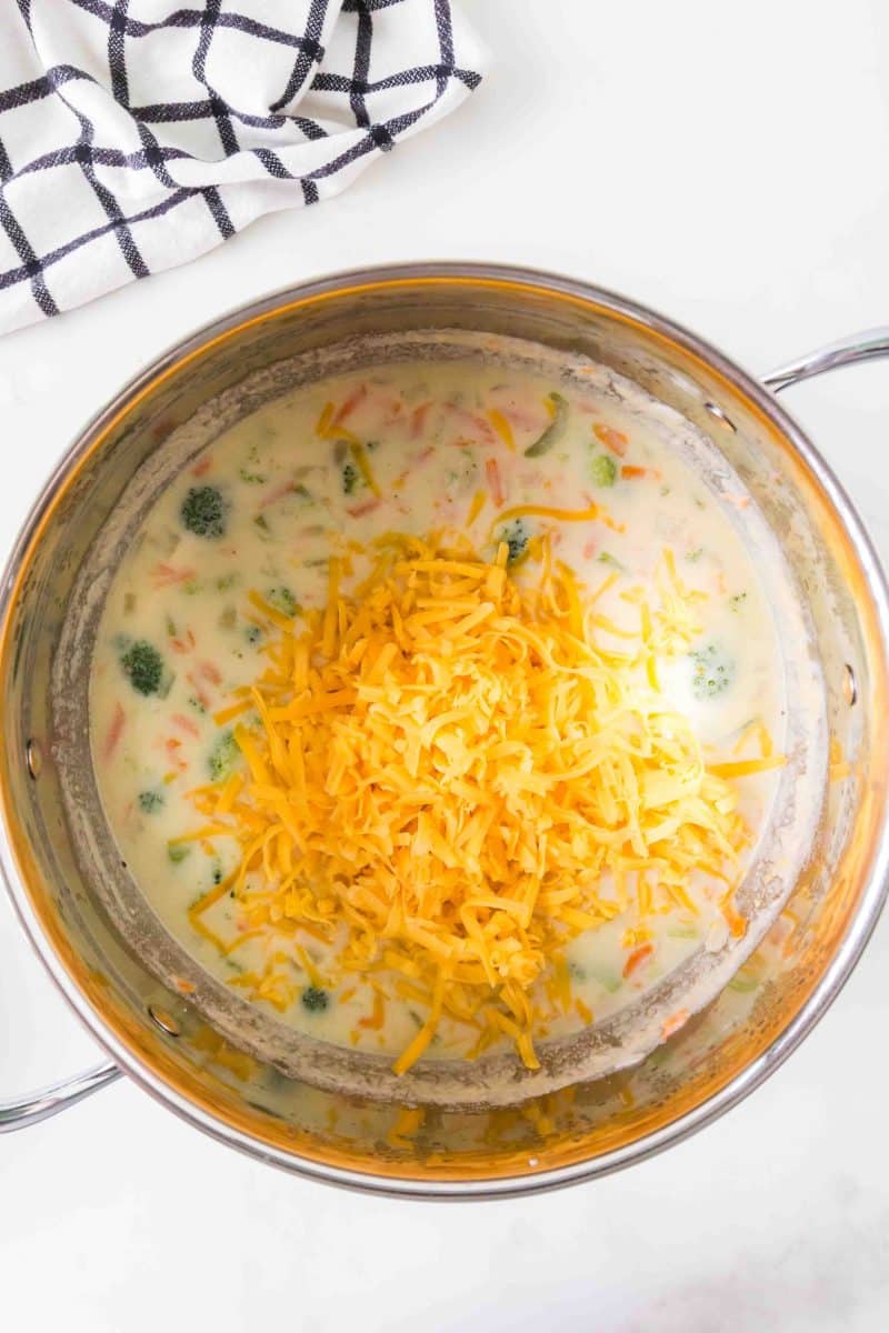Shredded cheddar cheese melting into broccoli soup. Hostess At Heart