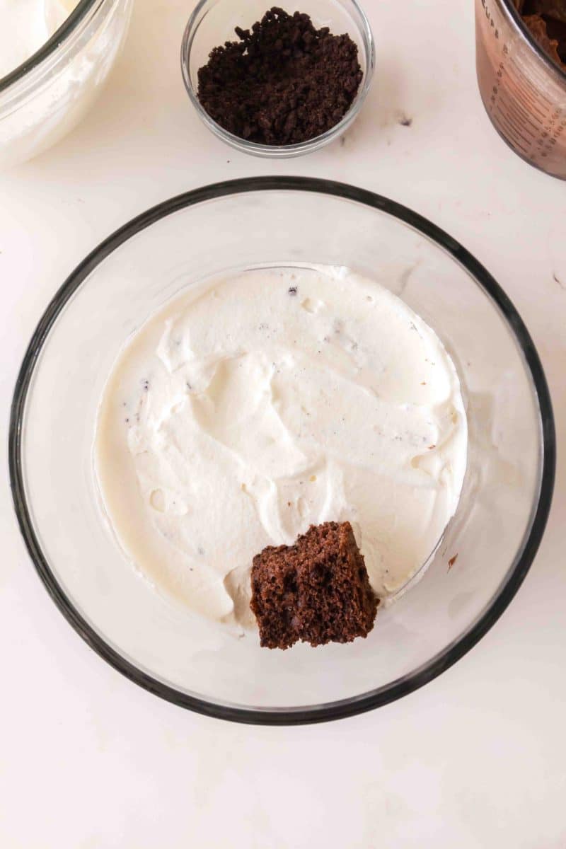 Chunks of chocolate cake added to a whipped topping in a trifle bowl. Hostess At Heart