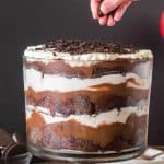 Side angle of a trifle bowl filled with layers of chocolate cake, pudding, whipped cream and oreo cookie crumbs. Hostess At Heart