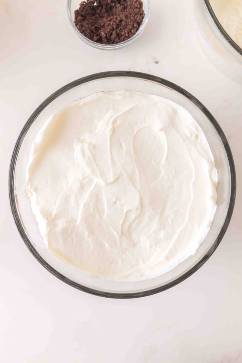 Top down view of a layer of whipped topping to be make into a layered dessert. Hostess At Heart
