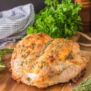 Tableview of a Roasted Turkey breast that was baked with an herb butter sitting on a cutting board. Hostess At Heart