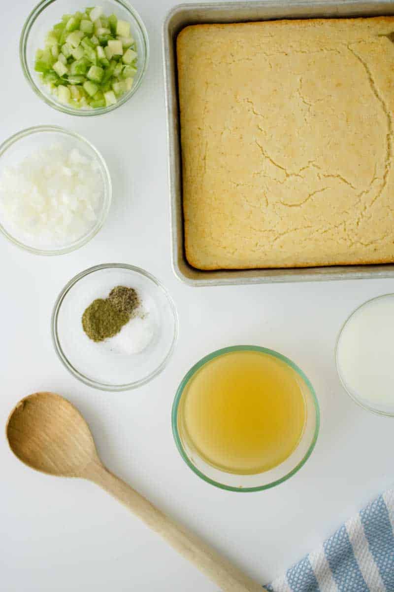Ingredients used to make a Southern Cornbread Dressing Recipe including pre-made cornbread, chicken stock, buttermilk, celery, onion, and spices - Hostess At Heart