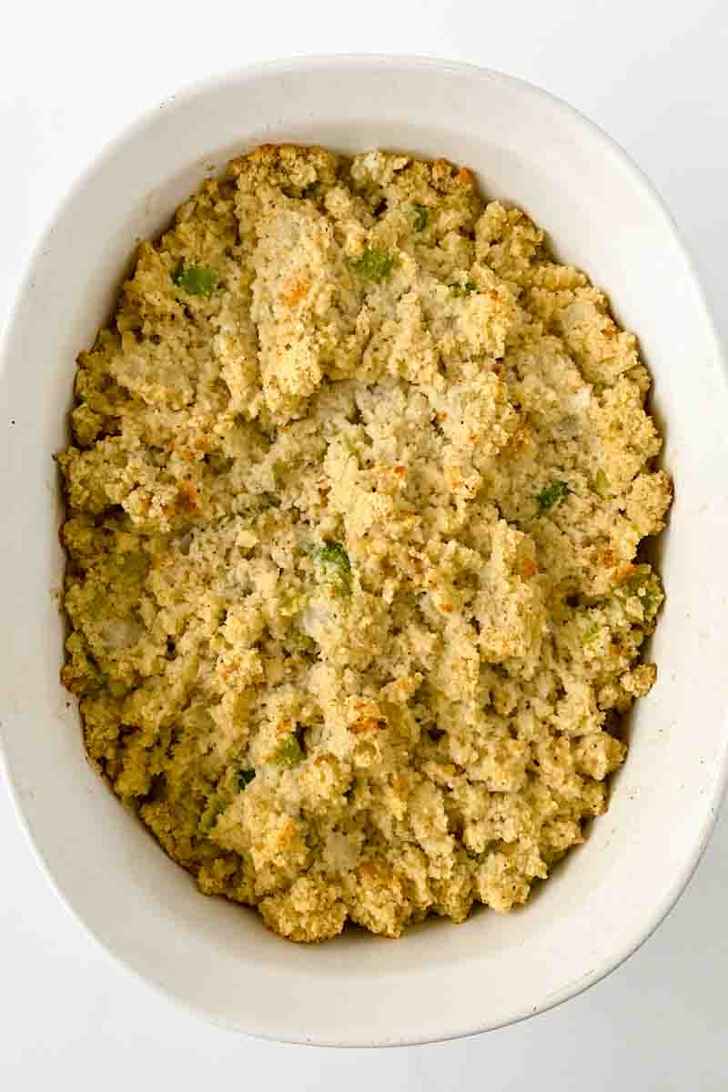 Top down view of a white baking dish filled with cornbread dressing that's been baked to a golden brown. Hostess At Heart