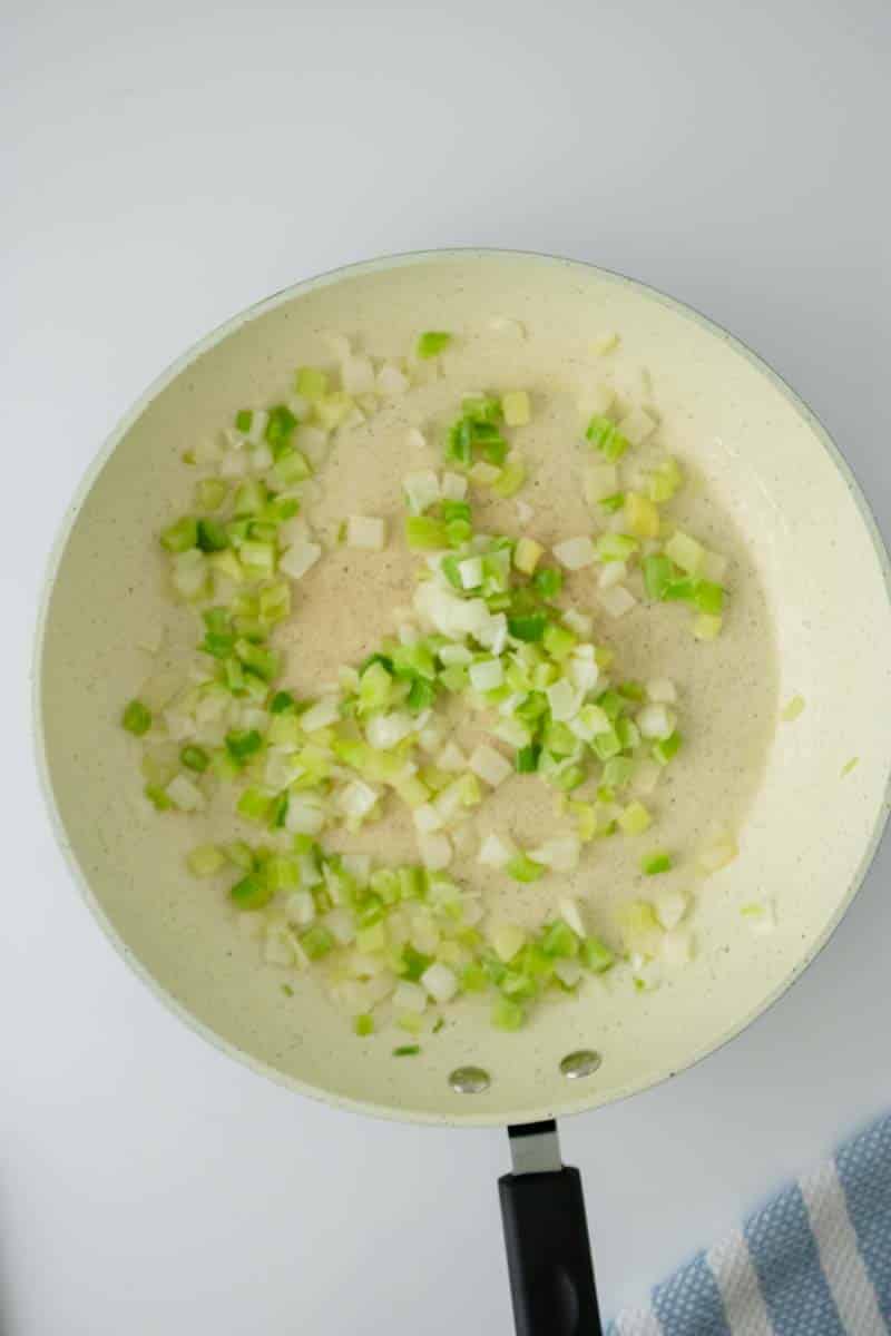 A skillet containing onion and celery that's been cooked until softened. Hostess At Heart