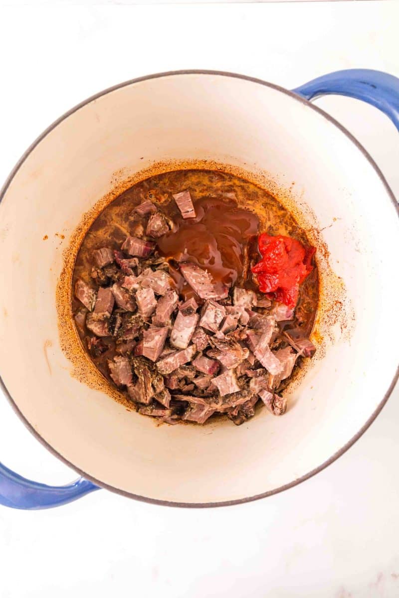 Top down view of a dutch oven filled with leftover brisket chili ingredients. Hostess At Heart