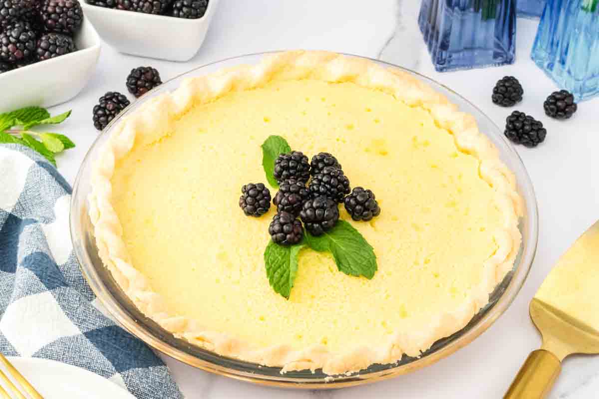 Whole buttermilk pie with a creamy vanilla custard filling garnished with fresh blackberries and mint. Hostess At Heart